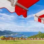 Awning over bright sunny blue sky with bench and sea view